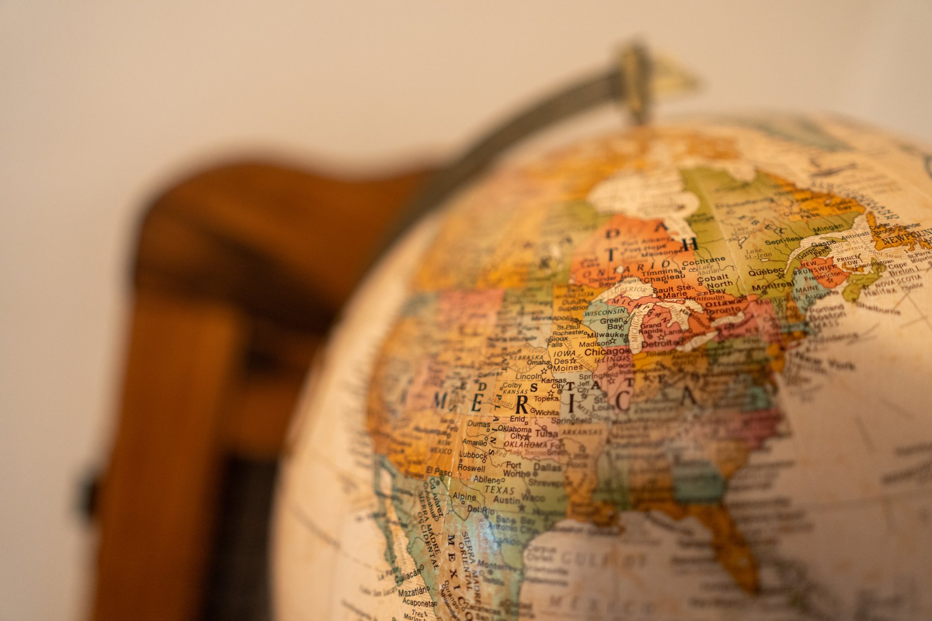 This close-up shot features a vintage-style globe, prominently displaying North America with detailed political boundaries and city names. The warm, soft lighting creates an inviting and educational mood, highlighting the intricate cartography.